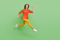 Photo of charming pretty young woman wear red shirt smiling jumping high running fast empty space isolated green color Royalty Free Stock Photo