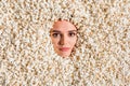 Photo of charming smiling young woman face curious peeking hole covered tasty caramel popcorn