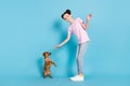 Photo of charming sweet school girl wear pink t-shirt smiling training small friend waving hi isolated blue color