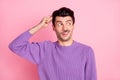 Photo of charming unsure young man dressed purple pullover forget something finger head isolated pink color background Royalty Free Stock Photo