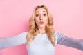 Photo of charming young happy woman send air kiss you make selfie isolated on pastel pink color background