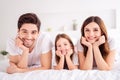 Photo of charming young lady guy little girl happy family lying sheets leaning hands head toothy smiling good mood spend Royalty Free Stock Photo