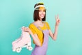 Photo of charming young nice woman wear tennis hat hold roller skates show v-sign isolated on teal color background