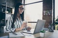 Photo of cheerfu smiling happy joyful girl holding disposable cup of coffee sitting at table with laptop on it looking Royalty Free Stock Photo