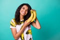 Photo of cheerful afro american charming girl hold bananas isolated over teal color background Royalty Free Stock Photo