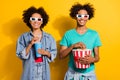 Photo of cheerful afro american people couple movie glasses eat pop corn drink isolated on yellow color background Royalty Free Stock Photo