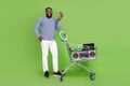 Photo of cheerful afro guy wear grey pullover buying credit card modern devices isolated green color background