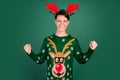 Photo of cheerful astonished guy celebrate victory wear horns deer ornament pullover isolated green color background