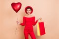 Photo of cheerful attractive positive young woman hold shopper bag balloon sale isolated on beige color background