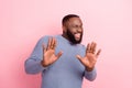 Photo of cheerful charismatic confident guy raise hands wink eye wear grey shirt isolated pink color background