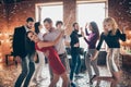 Photo of cheerful charming positive couple of two people dancing valse surrounded by their fellows in falling confetti Royalty Free Stock Photo