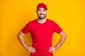 Photo of cheerful confident delivery man wear red outfit smiling hands arms waist isolated yellow color background Royalty Free Stock Photo