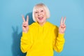 Photo of cheerful cool nice old woman make v-signs hello good mood isolated on pastel blue color background