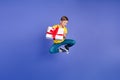 Photo of cheerful crazy boy wear trendy clothes hold birthday gift special season offer empty space isolated on violet Royalty Free Stock Photo