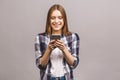 Photo of cheerful cute beautiful young woman chatting by mobile phone isolated over grey wall background Royalty Free Stock Photo