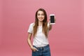 Photo of cheerful cute beautiful young woman chatting by mobile phone isolated over pink wall background. Royalty Free Stock Photo