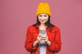 Photo of cheerful cute beautiful young woman chatting by mobile phone isolated over pink wall background Royalty Free Stock Photo