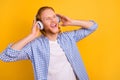 Photo of cheerful cute handsome screaming guy wearing headphones shouting words and lines of his favorite song dreaming