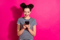 Photo of cheerful cute nice charming girlfriend browsing through her phone isolated over vivid fuchsia bright color