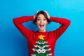 Photo of cheerful excited lady santa helper dressed print xmas sweater arms hands head open mouth isolated blue color Royalty Free Stock Photo