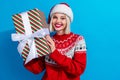 Photo of cheerful excited woman lady santa elf wear ornament pullover rising x-mas gift isolated blue color background Royalty Free Stock Photo