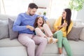 Photo of cheerful family happy positive smile mom dad tickle daughter have fun laugh sit sofa indoors Royalty Free Stock Photo