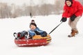 Photo of cheerful father skating son on tubing in winter afternoon Royalty Free Stock Photo