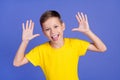 Photo of cheerful foolish preteen boy teasing fooling grimacing on purple color background