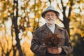 Photo of cheerful friendly aged grey white hair grandpa feel young walk street city park way alley enjoy sunny day hold