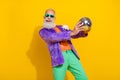 Photo of cheerful funky man wear purple velvet jacket rising discotheque ball dancing isolated yellow color background