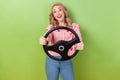 Photo of cheerful funky nice person toothy smile hands hold car wheel have good mood isolated on green color background Royalty Free Stock Photo