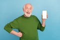 Photo of cheerful funny granddad hold demonstrate empty space telephone screen isolated on blue color background