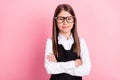 Photo of cheerful happy positive small girl hold hands crossed confident glasses on pink color background