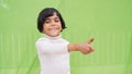 Photo of cheerful happy young small girl make fingers thumbs up smile recommend isolated on green color background Royalty Free Stock Photo