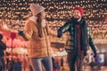 Photo of cheerful jolly couple walk on x-mas evening advent event under outdoors lights wear coats hats scarf
