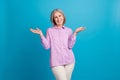 Photo of cheerful lovely lady wear violet stylish clothes showing arms rejoice nice meeting good mood isolated on blue Royalty Free Stock Photo