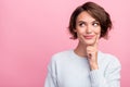 Photo of cheerful minded young positive woman dream look empty space hand chin isolated on pink color background