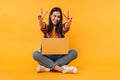 Photo of cheerful nice woman showing peace sign while sitting on floor Royalty Free Stock Photo