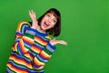 Photo of cheerful nice young woman amazed good mood raise hands palms smile isolated on green color background Royalty Free Stock Photo