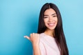 Photo of cheerful nice young woman point finger empty space thumb isolated on pastel blue color background Royalty Free Stock Photo