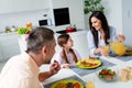 Photo of cheerful parents communicate pour fresh juice small daughter domestic food plate serenity house kitchen inside Royalty Free Stock Photo