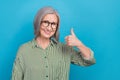 Photo of cheerful person demonstrate thumb up approval rate isolated on blue color background