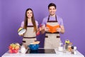 Photo of cheerful positive boyfriend girlfriend dressed chef outfit preparing delicious dish isolated purple color