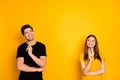 Photo of cheerful positive cute nice charming pretty couple holding pens wearing black t-shirt smiling toothily looking Royalty Free Stock Photo