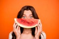 Photo of cheerful positive cute nice charming pretty girlfriend looking out of wedge of watermelon watching you