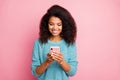 Photo of cheerful positive cute pretty sweet girl smiling toothily beaming browsing through telephone isolated pastel Royalty Free Stock Photo