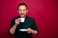 Photo of cheerful positive handsome masculine man readying to drink well smelling coffee with eyes closed isolated vivid