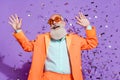 Photo of cheerful positive joyful cool old man confetti fall look copyspace dream isolated on violet color background Royalty Free Stock Photo