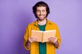 Photo of cheerful positive smile young man read book information isolated over violet color background Royalty Free Stock Photo