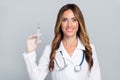 Photo of cheerful positive woman doc dressed white coat holding syringe smiling isolated grey color background Royalty Free Stock Photo